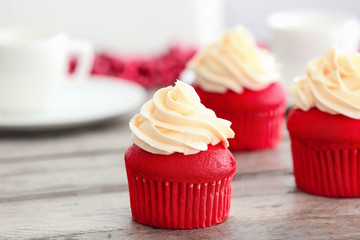 Delicious red velvet cupcakes on table