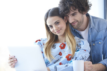 Enjoy spending time together. Young couple surfing on the net at home.