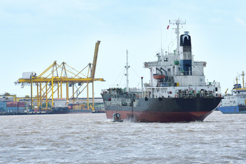 Fototapeta premium Large cargo ships. It is moving through the water waves and headed to the port one of Thailand.