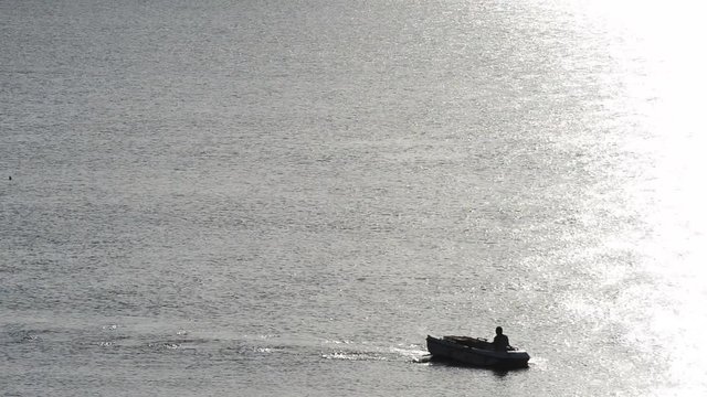 pescatore in mezzo al mare alle prime luci del giorno