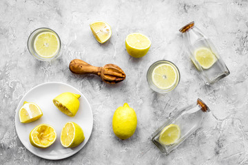 Fresh homemade lemonade. Lemons, juicer, glass for beverage on grey stone background top view