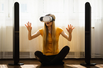 Girl wearing virtual reality goggles at home