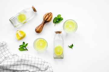 Prepare refreshing beverage lemonade. Lemons, juicer, bottle on white background top view copyspace