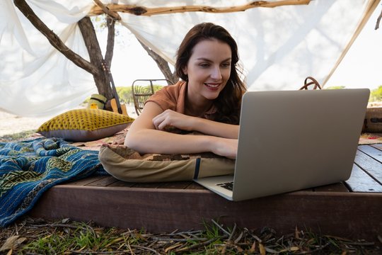 Young woman using laptop in tent