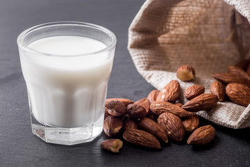Almond milk in glass with almonds