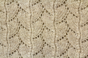 Background texture of beige pattern knitted fabric made of cotton or wool closeup