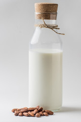 Almond milk in glass with almonds