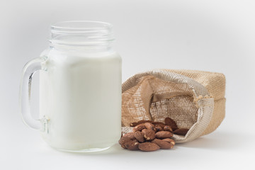 Almond milk in glass with almonds