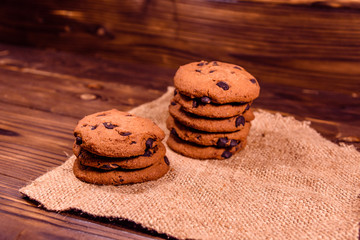 Chocolate chip cookies on sackcloth on a wooden table