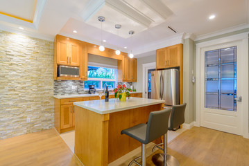 Modern, bright, clean, kitchen interior with stainless steel appliances in a luxury house