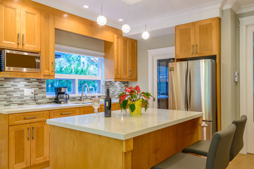 Modern, bright, clean, kitchen interior with stainless steel appliances in a luxury house