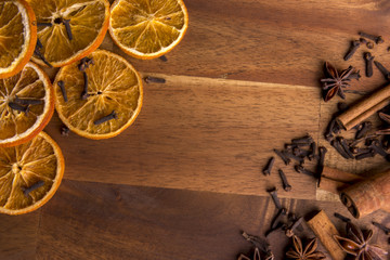 Dried orange slices on a wooden background arranged with cinnamon and anis