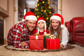 family, christmas, x-mas, happiness and people concept - smiling family in santa helper hats with many gift boxes