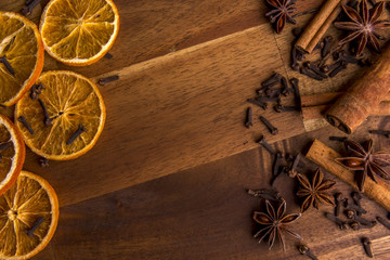 Dried orange slices on a wooden background arranged with cinnamon and anis