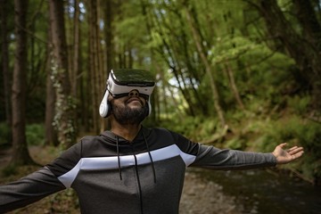Young man wearing vr glasses while standing with arms