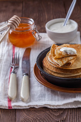 A stack of pancakes with sour cream and honey for Maslenitsa