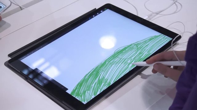 The girl draws on a tablet