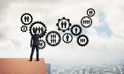 Businessman on house roof presenting teamwork and connection con