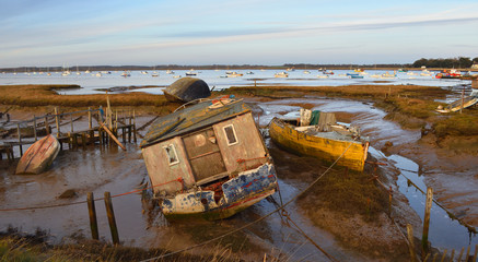 Fototapeta na wymiar Old Boats on mud flats at Felixstowe Ferry early evening