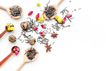 Dried tea leaves near supplements like flowers and spices on white background top view pattern copyspace