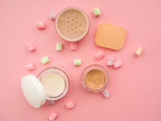 concealer, powder, eyeshadow on a pink background, the concept of beauty and makeup