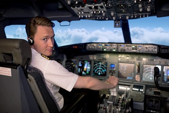 Portrait of handsome young male pilot flying airplane