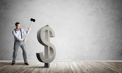 Determined banker man in empty concrete room breaking dollar figure