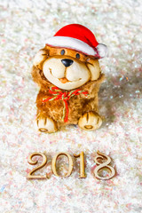 Wooden figures of 2018 on snow. Christmas atmosphere. The new year 2018. A toy dog is a symbol of the New Year.
