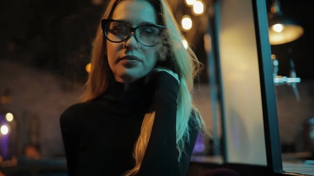 Woman vaping hookah in night club