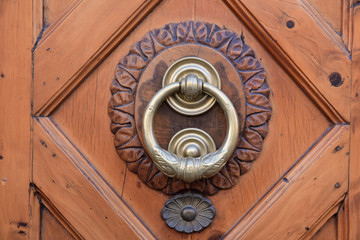 Poignée de porte laiton sur rosace en bois sculpté