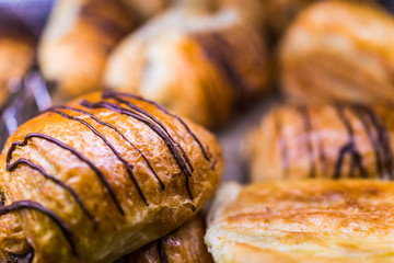 Macro closeup of many chocolate drizzled croissants