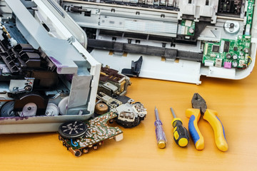 On the desktop is disassembled equipment and tools for repair.