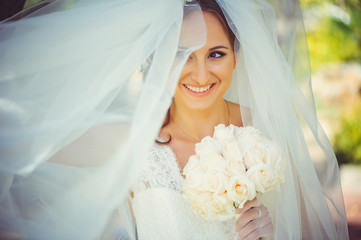 Naklejka premium tender happy bride in veil, happy woman in wedding dress with bouquet in hands, white veil covers face, gentle and warm