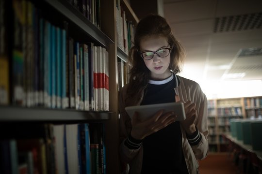 Woman using digital tablet in library room