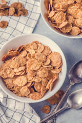 dry breakfast in white plates with milk on a gray background with a towel in a strip, vertically