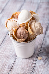 Creme brulee, chocolate, vanilla ice cream in a waffle horn on a light background, vertically