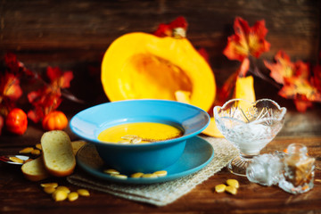 Pumpkin and carrot soup with cream and parsley on dark wooden background Top view