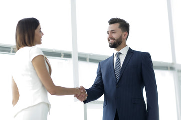 Fototapeta na wymiar An attractive business man and woman team shaking hands