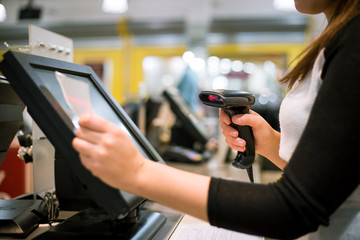 Young woman hand doing process payment on a touchscreen cash register, finance concept