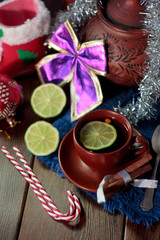 Christmas tea on wooden table with lime and candy canes.