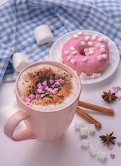 rose mug of hot chocolate on the white table with rose donut and marshmallows.