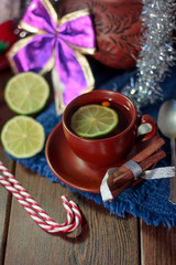 Christmas tea on brown ceramic cup with lime