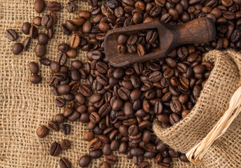 Wooden scoop put on background of coffee beans.