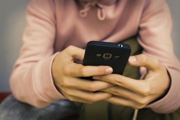 hands with mobile phone on street