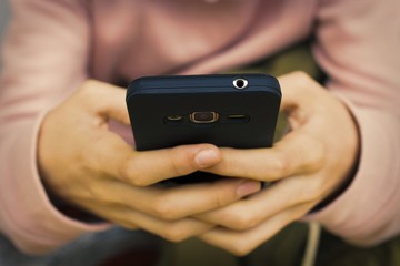 hands with mobile phone on street
