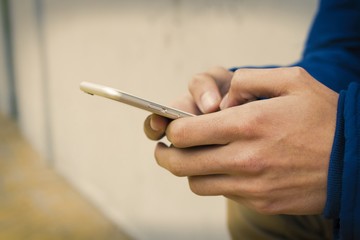 hands with mobile phone on street