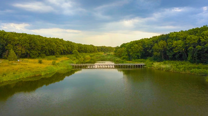 Aerial Drone Flight Footage: Back Flight above calm Water and forest in sunset soft light. Magestic landscape.