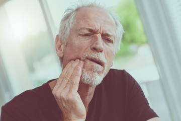 Portrait of mature man with toothache