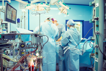 Team of surgeon in uniform perform operation on a patient using laparoscopic equipment at modern...