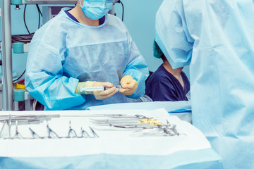 Close up hands of surgery assistant prepearing steralized surgical tools for surgery operation....